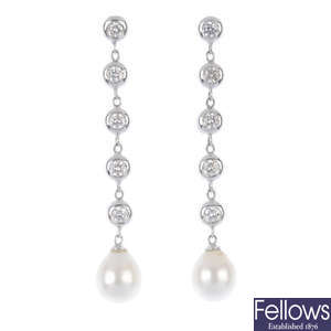 A pair of cultured pearl and fracture-filled diamond ear pendants.