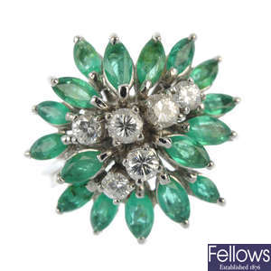 An emerald and diamond floral dress ring.