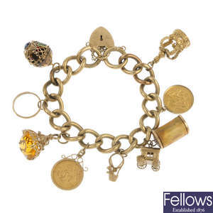 A 1970s 9ct gold charm bracelet, suspending two half-sovereigns.