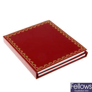 CARTIER - a red wallet with booklet, CD and paperwork.