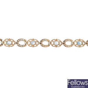 A 9ct gold blue topaz horseshoe bracelet.