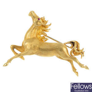CARTIER - an 18ct gold ruby horse brooch.