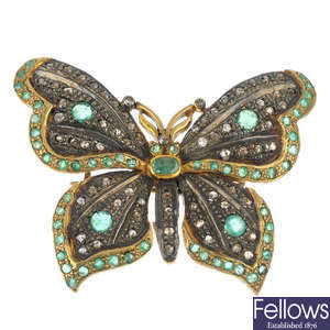 A diamond and emerald butterfly brooch.