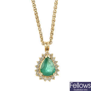 An emerald and diamond cluster pendant.