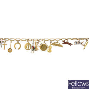 An early 20th century 9ct gold fancy-link bracelet suspending fourteen charms.