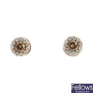 A pair of 'brown' diamond and diamond cluster ear studs. 