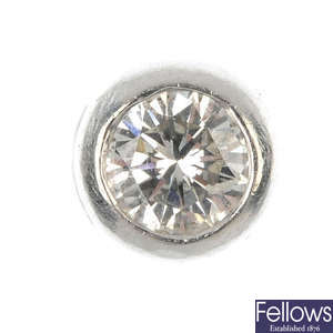 A diamond single-stone ear stud and a loose diamond.