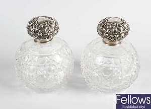 A pair of early 20th century hallmarked silver topped cut glass scent bottles