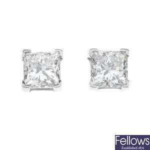 A pair of platinum square-shape diamond single-stone ear studs. 