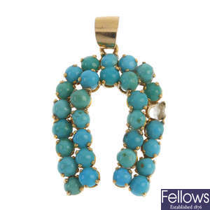 A turquoise horseshoe pendant.