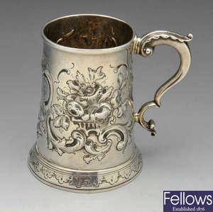A George III silver mug with embossed decoration.