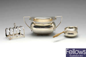 A 1920's twin handled sugar bowl, plus a modern silver tea strainer and toast rack. 