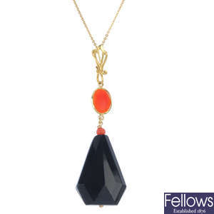A coral necklace and an onyx and coral pendant.