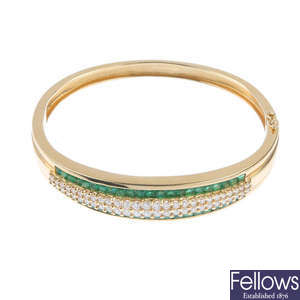 An emerald and diamond bangle.