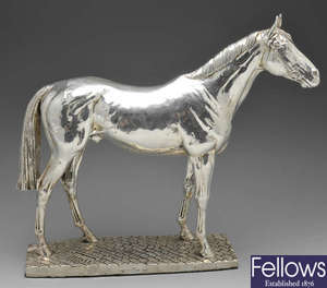 A filled silver model of a standing horse.
