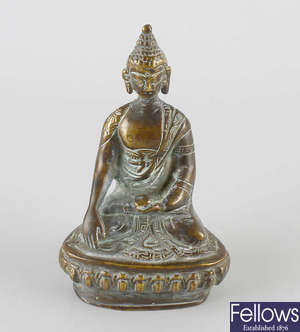 A small late 17th/early 18th century brass figure modelled as a Buddha.  