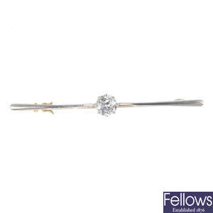 An early 20th century platinum and gold diamond single-stone bar brooch.