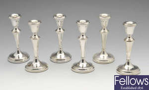 A set of six modern silver small candlesticks with filled bases.