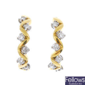 A pair of gold diamond half-circle ear hoops.
