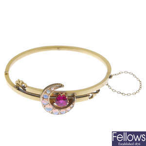 A late 19th century 15ct gold opal and synthetic ruby bangle.