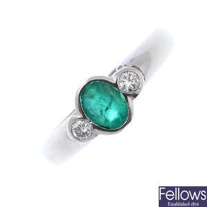 A platinum emerald and diamond three-stone ring.