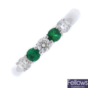 A platinum emerald and diamond half-circle eternity ring.