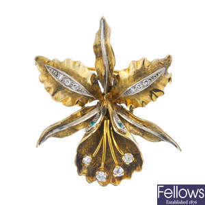 A diamond and emerald floral brooch.