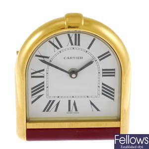A gold plated travel alarm clock by Cartier.