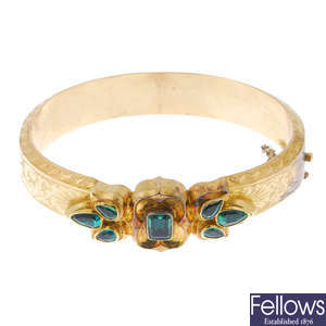 A late 19th century 18ct gold emerald hinged bangle.