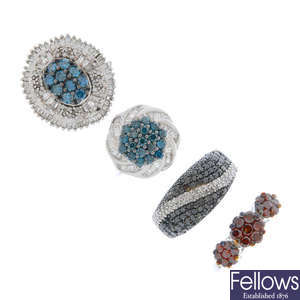 A selection of four coloured diamond and diamond rings.
