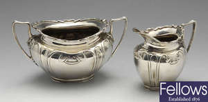 An Art Nouveau silver sugar bowl and cream jug, etc.