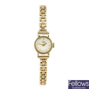 LONGINES - a lady's yellow metal bracelet watch.