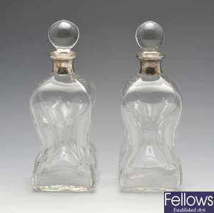 A pair of modern silver mounted clear glass glug-glug decanters.