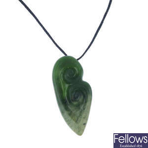A carved New Zealand jade double Koru pendant by Paddy Cooper.