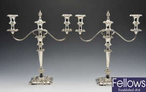 A modern pair of silver twin branch candelabra, filled.