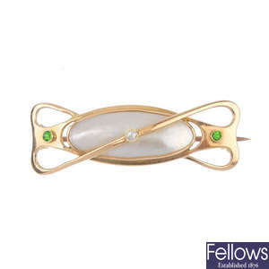 An early 20th century 15ct gold mother-of-pearl, diamond and demantoid garnet brooch.