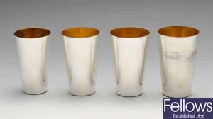 A set of four modern graduated silver beakers. 