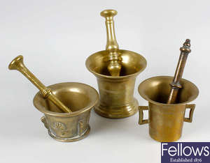 A box containing seven assorted bell metal mortars with pestles.