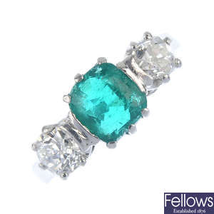 A platinum emerald and diamond three-stone ring.