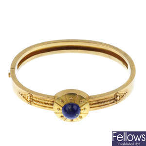 A late 19th century 18ct gold lapis lazuli hinged bangle.