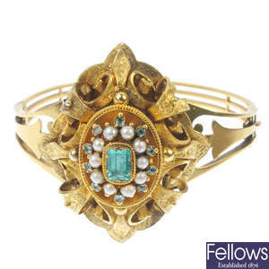 A mid Victorian gold foil-back emerald and split pearl hinged bangle, circa 1860. 