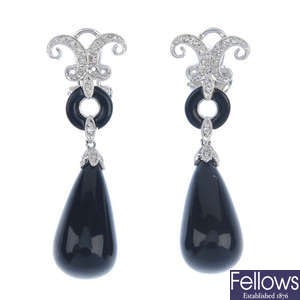 A pair of diamond and onyx ear pendants.