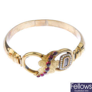 A mid 19th century gold, garnet and split pearl hinged bangle.