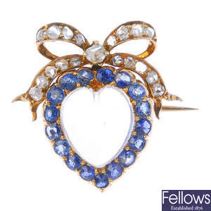An early 20th century gold moonstone, sapphire and diamond heart and bow brooch.