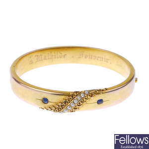 A late 19th century gold sapphire and split pearl hinged bangle.