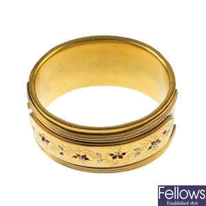 A gold plated split pearl and red paste hinged bangle.