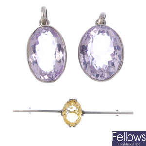 Two amethyst pendants and a citrine bar brooch.
