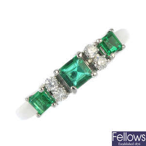 An 18ct gold emerald three-stone and diamond ring.