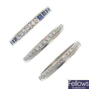 A selection of three diamond and gem-set full and half-circle eternity rings.
