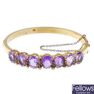 A late 19th century gold amethyst and split pearl hinged bangle